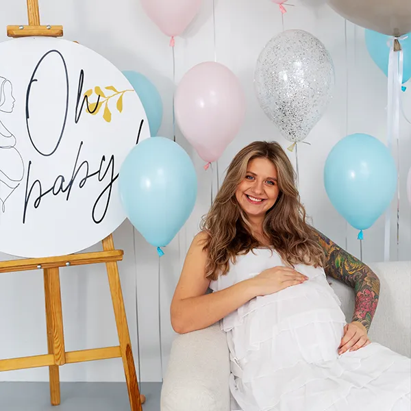 Mom-to-be posing with friends in a photo booth at a baby shower.